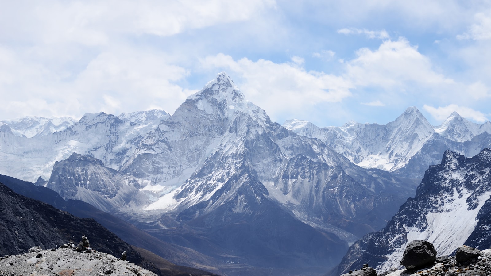 A hiker looking out over layered mountain ridges under a clear sky.