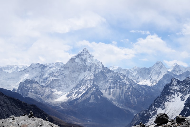 A hiker looking out over layered mountain ridges under a clear sky.