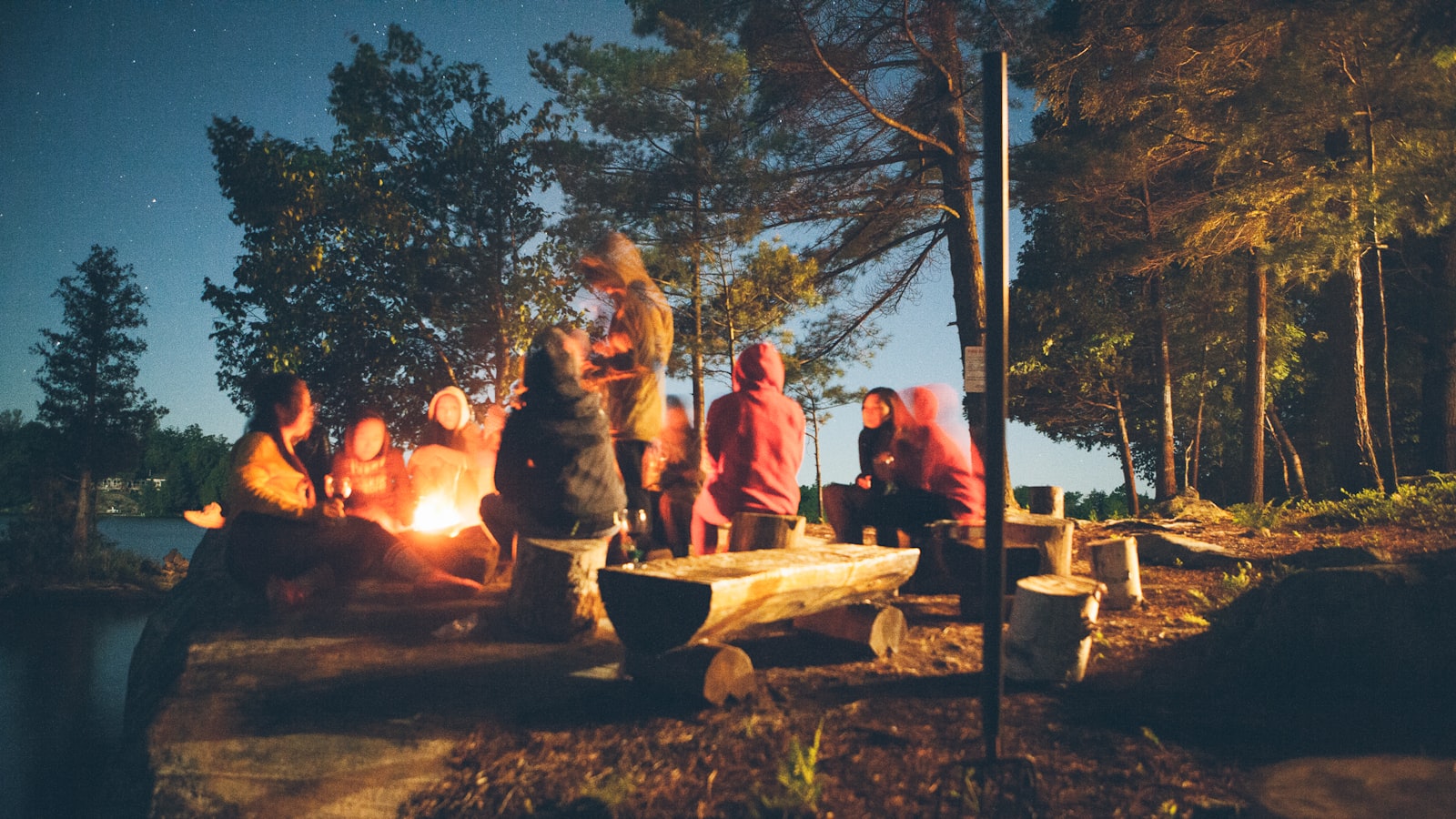 A small, contained campfire burning inside a stone ring at dusk.
