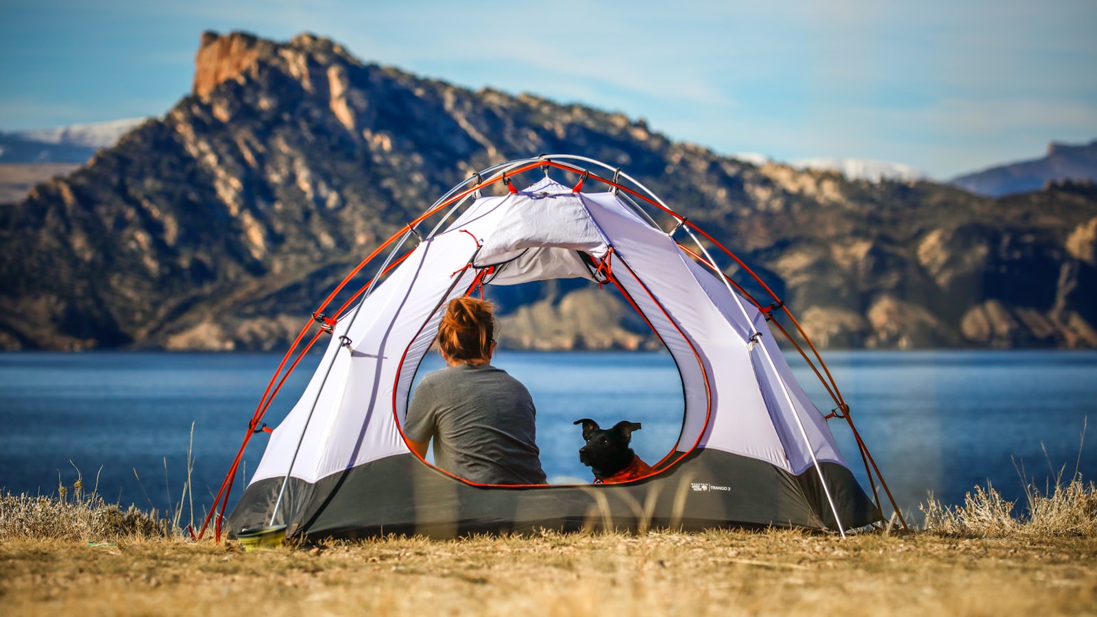 A cozy sleeping bag and pillow laid out inside a tent in soft morning light.