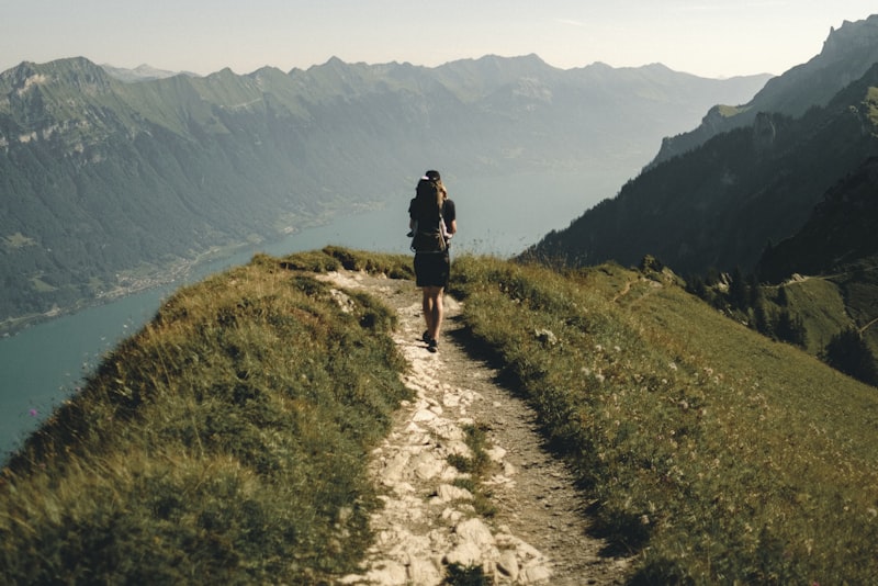 A dirt hiking trail winding gently uphill through open countryside.