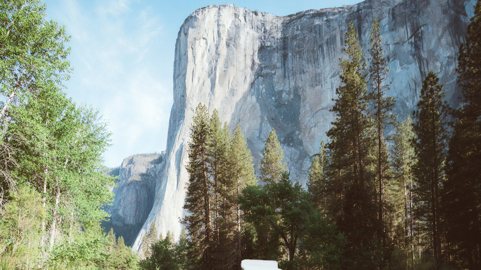 A hiking backpack standing upright on a rock outdoors with its straps visible.